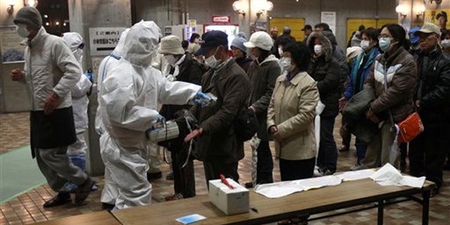 Evacuees are screened for radiation exposure at a testing center March 15 in Japan's Koriyama city.