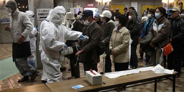 Evacuees are screened for radiation exposure at a testing center March 15 in Japan's Koriyama city.