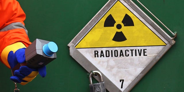 A German police officer uses a Geiger counter to measure the radiation of a Castor container on a transport train, during a stop in Neunkirchen near Saarbruecken November 25, 2011. The Castor (Cask for Storage and Transport Of Radioactive material) train is carrying 11 containers of spent German nuclear fuel on route from France after being reprocessed, to the nuclear waste storage facility of Gorleben in north eastern Germany. REUTERS/Alex Domanski (GERMANY - Tags: POLITICS ENVIRONMENT) - RTR2UGDT