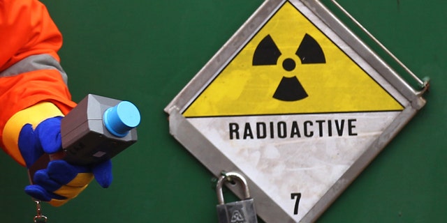 File photo - A German police officer uses a Geiger counter to measure the radiation of a Castor container on a transport train, during a stop in Neunkirchen near Saarbruecken November 25, 2011. (REUTERS/Alex Domanski)