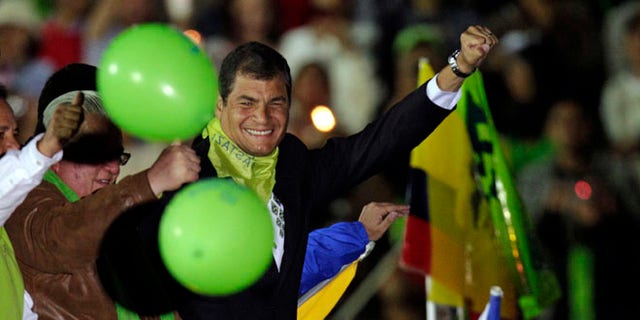 Ecuador's President Rafael Correa lifts his fist as he arrives atop a car to participate in a in event marking the fifth anniversary of his administration in Cuenca, Ecuador, Saturday, Jan. 14, 2012. (AP Photo/Dolores Ochoa)