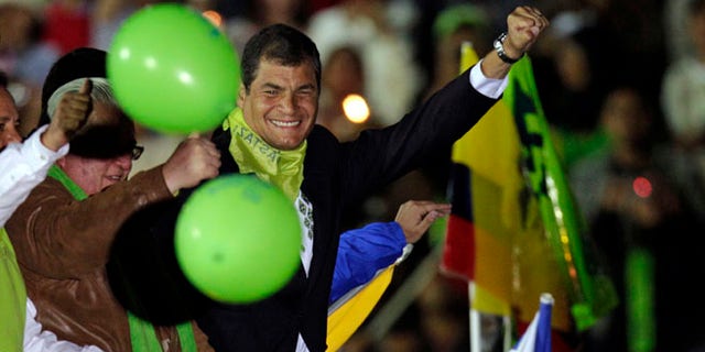 Ecuador's President Rafael Correa lifts his fist as he arrives atop a car to participate in a in event marking the fifth anniversary of his administration in Cuenca, Ecuador, Saturday, Jan. 14, 2012. (AP Photo/Dolores Ochoa)