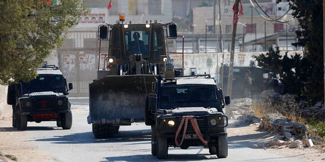 Israeli security forces raid the West Bank village of Deir Abu Mash'al near Ramallah, Saturday.