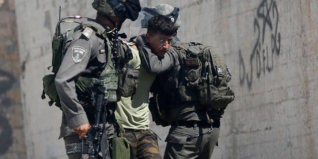 Israeli border police arrest a Palestinian during clashes in the West Bank village of Deir Abu Mash'al near Ramallah, Saturday.