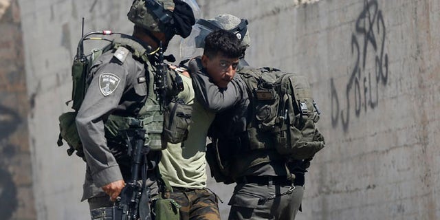 Israeli border police arrest a Palestinian during clashes in the West Bank village of Deir Abu Mash'al near Ramallah, Saturday.