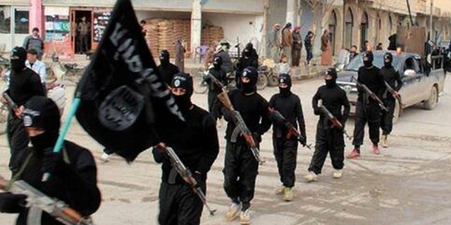 ISIS fighters march in Raqqa, Syria.