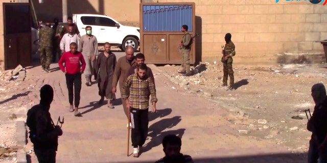 ISIS fighters who surrendered enter a base of the U.S.-backed Syrian Democratic Forces in Raqqa.