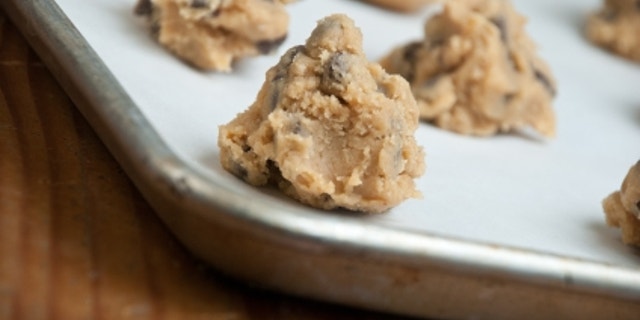A pan of freshly prepared homemade chocolate chip cookie dough sits on the counter waiting to go into the oven.