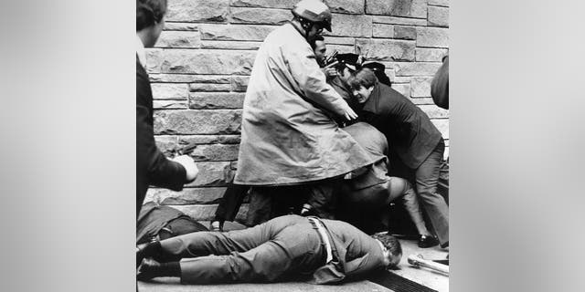 In this March 30, 1981, file photo, White House press secretary James Brady lies wounded on the sidewalk outside a Washington hotel after being shot during an assassination attempt on U.S. President Ronald Reagan, Monday, March 30, 1981.