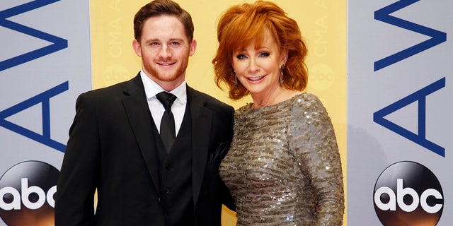 Race driver Shelby Blackstock and singer Reba McEntire arrive at the 50th Annual Country Music Association Awards in Nashville, Tennessee, U.S., November 2, 2016. REUTERS/Jamie Gilliam - RTX2RMKA