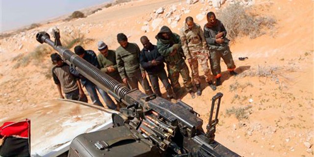Libyan rebels pray 75 miles east of Sirte in eastern Libya March 28.