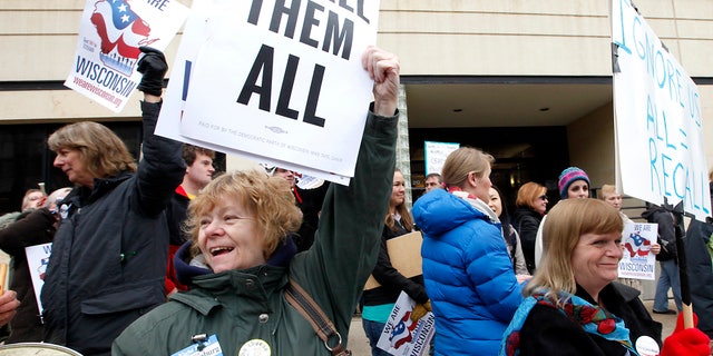 This April 1, 2011 file photo shows Chris Taylor, left, and Peppi Elder, right, joining demonstrators calling for the recall of State Sen. Dan Kapanke, R-LaCrosse, outside the Wisconsin Government Accountability Board in Madison, Wis. (AP)