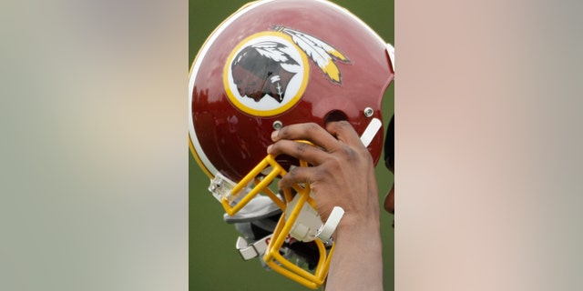 In this file photo, Washington Redskins Marko Mitchell puts his helmet on during their NFL football minicamp practice at their training facility in Ashburn, Va.