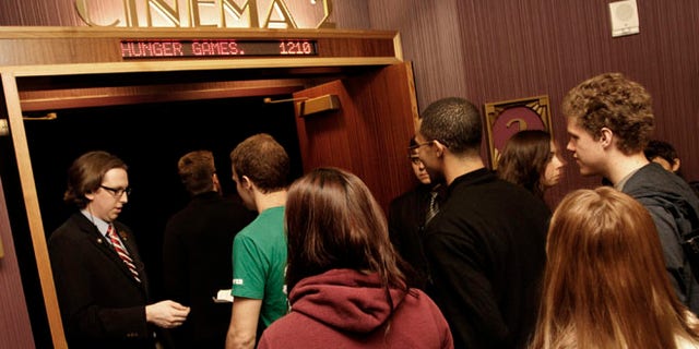 Workers for Regal Entertainment Group, like the one seen here collecting tickets from movie-goers, have had their work weeks shortened in a new company-wide mandate. Internal documents obtained by FoxNews.com show that the cuts were enacted in response to the Affordable Care Act.