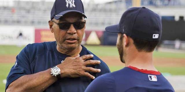March 13, 2012: New York Yankees Hall of Famer Reggie Jackson (L) talks with Boston Red Sox infielder Dustin Pedroia during workouts before a spring training baseball game in Tampa, Florida.