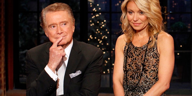 Television host Regis Philbin says goodbye with co-host Kelly Ripa (R) during his final show of on 