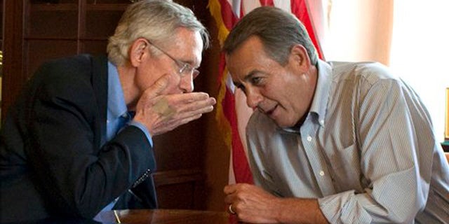 Senate Majority Leader Harry Reid holds his hand up as he whispers to House Speaker John Boehner during a photo opportunity in the House Speaker's office in Washington July 23.