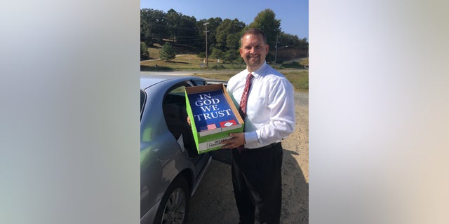 Arkansas Rep. Jim Dotson shows off new "In God We Trust" posters that will be hung in schools.