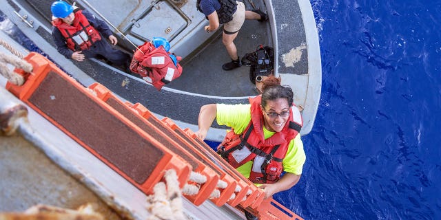 Tasha Fuiava, an American mariner who had been sailing for five months on a damaged sailboat, climbs the accommodation ladder to board the amphibious dock landing ship USS Ashland.