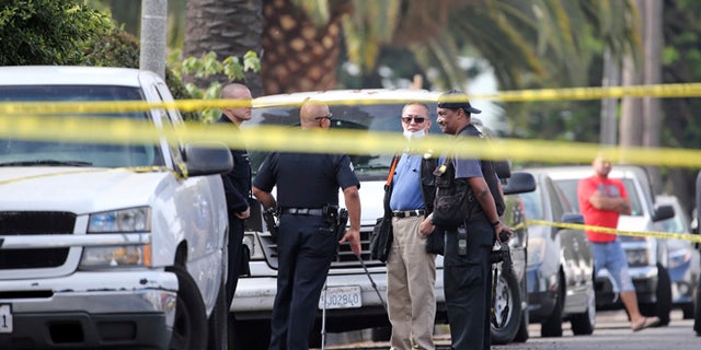 Los Angeles police investigators work the scene of a fatal shooting in the Crenshaw District neighborhood of Los Angeles, Saturday, Oct. 15, 2016.