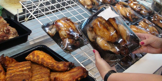 Young Woman's Hand Choosing Roasted Chicken On The Market