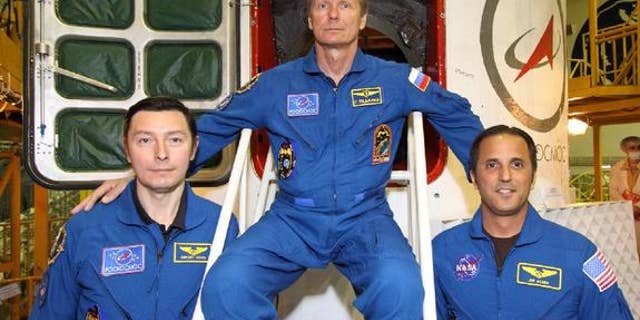 Sergei Revin (left), Gennady Padalka (center) and Joe Acaba (right) pose in front of the hatchway to their Soyuz TMA-04M spacecraft as they completed their final "fit check" inspection of the vehicle on May 11, 2012. The three will launch toward the space station on May 14.