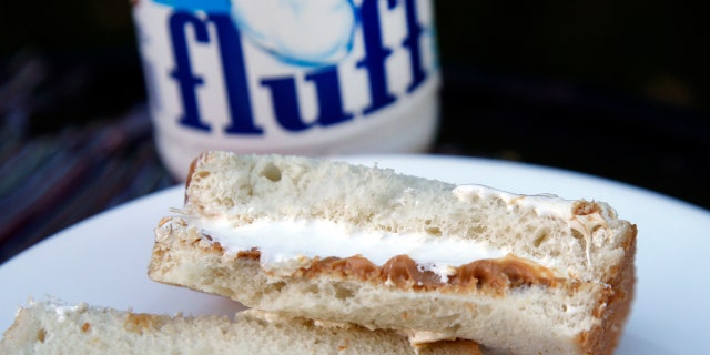 In this Sept. 27, 2013, file photo, a jar of Marshmallow Fluff and a Fluffernutter sandwich are displayed in North Andover, Mass. Archibald Query invented Fluff in 1917 in the Boston suburb of Somerville. The marshmallow concoction that's been smeared on a century's worth of sandwiches has inspired a festival and other sticky remembrances as it turns 100 in 2017. (AP Photo/Elise Amendola, File)