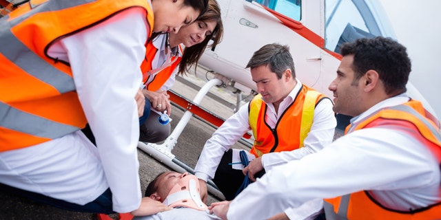 Group of paramedics carrying patient on a helicopter ambulance