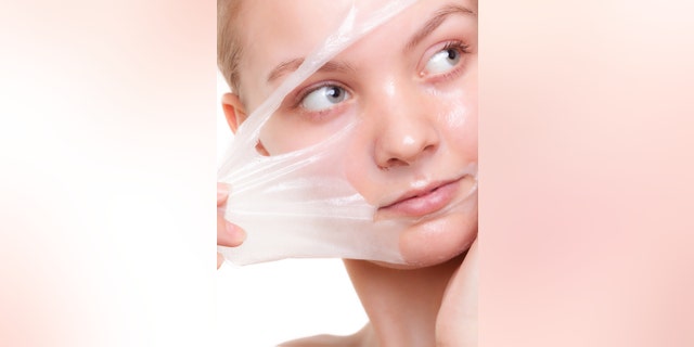 Portrait of girl young woman in facial peel off mask isolated on white. Peeling. Beauty and body skin care. Studio shot.