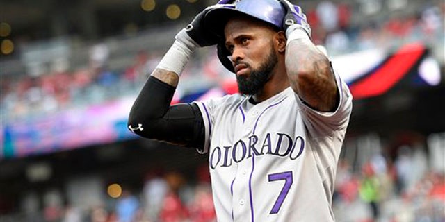 In this Aug. 7, 2015, file photo, Colorado Rockies shortstop Jose Reye adjusts his batting helmet before a baseball game against the Washington Nationals in Washington.