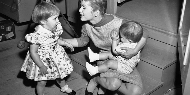 Debbie Reynolds is visited at the studio of "Say One For Me" by her children, Carrie 2½, and one-year-old Todd on Feb 27, 1959. (AP Photo)