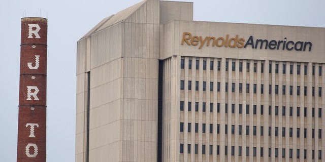 The headquarters of Reynolds American is seen next to the old R.J. Reynolds Tobacco smoke stacks from a previous manufacturing plant in downtown Winston-Salem, North Carolina May 23, 2014. REUTERS/Chris Keane