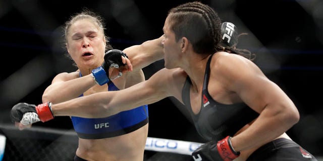Amanda Nunes, right, throws a punch at Ronda Rousey in the first round of their women's bantamweight championship mixed martial arts bout at UFC 207, Friday, in Las Vegas.