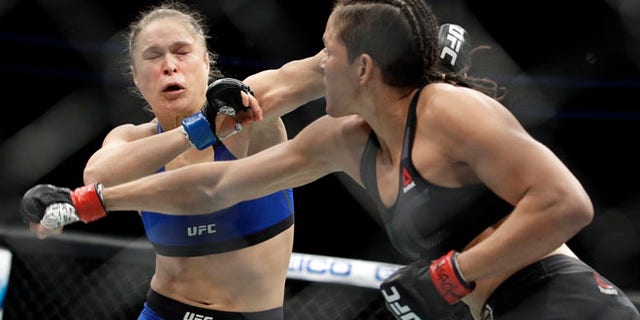 Amanda Nunes, right, throws a punch at Ronda Rousey in the first round of their women's bantamweight championship mixed martial arts bout at UFC 207, Friday, in Las Vegas.
