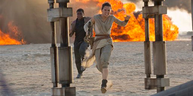 This photo provided by Disney/Lucasfilm shows Daisy Ridley, right, as Rey, and John Boyega as Finn, in a scene from the movie, "Star Wars: The Force Awakens," directed by JJ Abrams.  The movie opens in US theaters on Friday, Dec.  18, 2015. (David James/Disney/Lucasfilm via AP)
