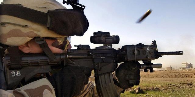 In this December 2004 file photo, a U.S. Army soldier fires a rifle during a fight with insurgents in Mosul, Iraq.