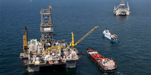 The Transocean Development Driller III, left, and the Transocean Development Driller II, right, the rigs drilling relief wells, are seen on the Gulf of Mexico near the coast of Louisiana Aug. 14. (AP Photo)