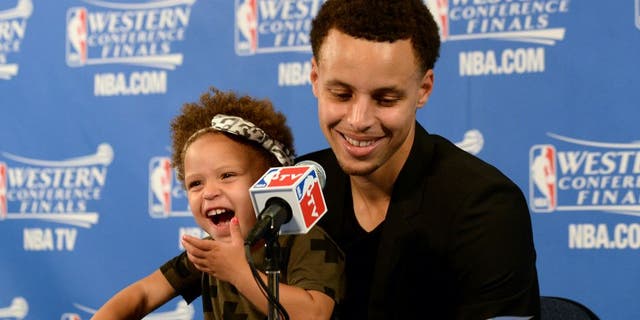 OAKLAND, CA - MAY 19: Stephen Curry #30 of the Golden State Warriors and his daughter Riley talking with the media at a press conference after the game against the Houston Rockets during Game One of the Western Conference Finals during the NBA Playoffs on May 19, 2015 at ORACLE Arena in Oakland, California. NOTE TO USER: User expressly acknowledges and agrees that, by downloading and or using this Photograph, user is consenting to the terms and conditions of the Getty Images License Agreement. Mandatory Copyright Notice: Copyright 2015 NBAE (Photo by Noah Graham/NBAE via Getty Images)