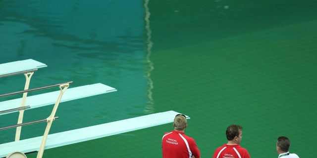 Maria Lenk Aquatics Centre - Rio de Janeiro, Brazil - 09/08/2016. Officials look at the Olympic diving pool (REUTERS/Antonio Bronic)