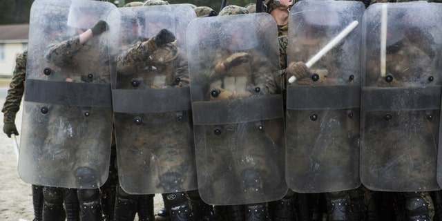 U.S. Marines with Battalion Landing Team, 1st Battalion, 6th Marine Regiment, 22nd Marine Expeditionary Unit (MEU), hold riot shields to prevent injury during a simulated riot at Camp Lejeune, N.C., Jan. 22, 2016. The Marines participated in the course to ensure mission readiness and to improve their ability to maintain control during a riot. (Credit: U.S. Marine Corps)
