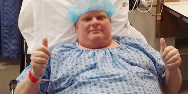 FILE - In this Monday, May 11, 2015 photo provided by Dan Jacobs, former Toronto Mayor Rob Ford gives a thumbs up before surgery in Toronto, to remove a cancerous tumor from his abdomen. On Thursday, March 17, 2016, Ford's chief of staff, Jacobs, said doctors are working on building his strength to be able to resume chemotherapy. In October 2015, doctors also discovered two cancerous growths on his bladder. He has been in the hospital since late February. (Courtesy Dan Jacobs via AP)
