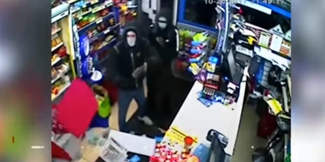 Police in the United Kingdom are looking for two would-be robbers who were chased from a store by an employee who threw what appeared to be alcohol at them.