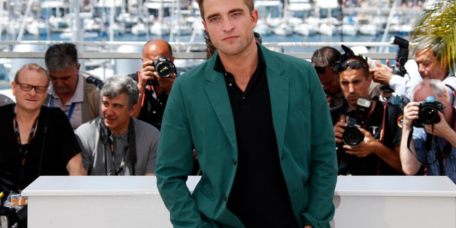 Cast member Robert Pattinson poses during a photocall for the film "The Rover" out of competition at the 67th Cannes Film Festival in Cannes May 18, 2014. REUTERS/Benoit Tessier (FRANCE - Tags: ENTERTAINMENT) - RTR3PO4N