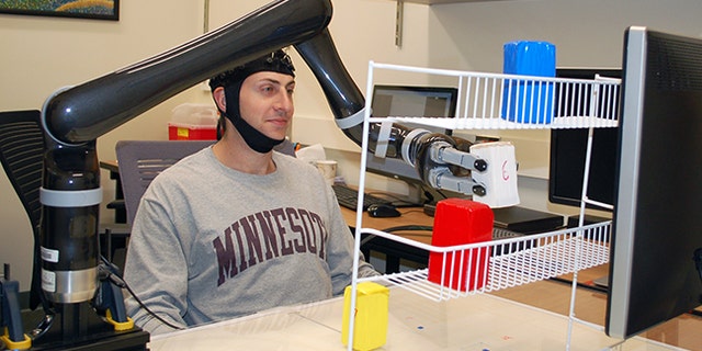 Research subjects at the University of Minnesota fitted with a specialized noninvasive brain cap were able to move the robotic arm just by imagining moving their own arms.