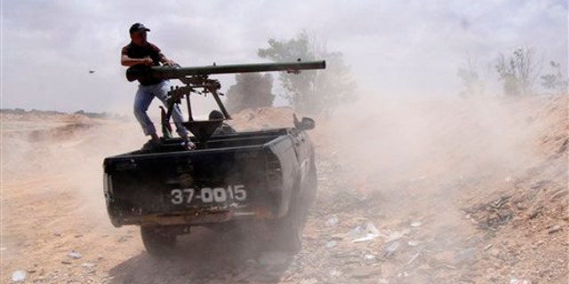 Libyan rebel fires a rocket toward pro-Muammar Qaddafi forces on the front line of Dafniya in Misrata, Libya, June 21.