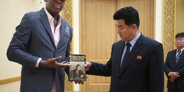 In this June 15, 2017, file photo, former NBA basketball star Dennis Rodman presents a book titled "Trump The Art of the Deal" to North Korea's Sports Minister Kim Il Guk Thursday, June 15, 2017, in Pyongyang, North Korea. (AP Photo/Kim Kwang Hyon, File)