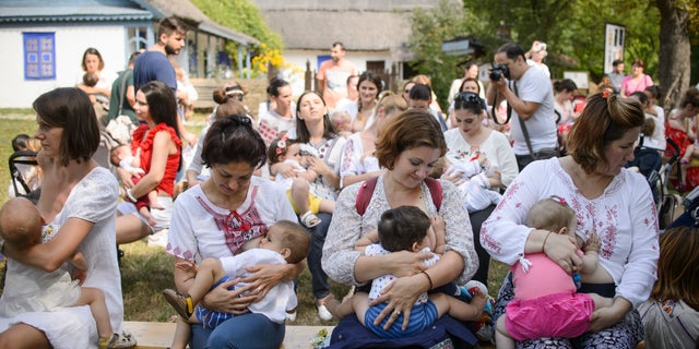 Women breastfeed their babies at an event promoting the freedom of mothers to breastfeed in public, during World Breastfeeding Week at the Village Museum in Bucharest, Romania, Saturday, Aug. 6, 2016. (AP Photo/Andreea Alexandru)