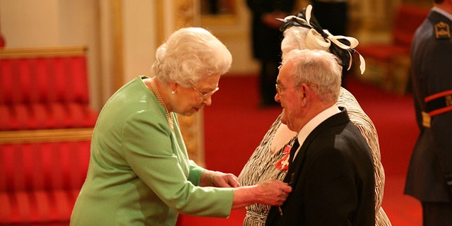 Penelope Jones and Ronald Jones as they receive their MBEs from Queen Elizabeth II at Buckingham Palace.
