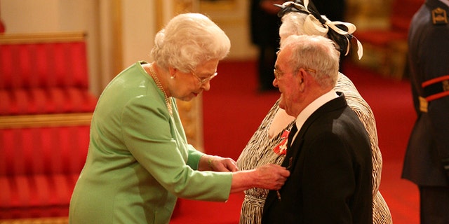 Penelope Jones and Ronald Jones as they receive their MBEs from Queen Elizabeth II at Buckingham Palace.