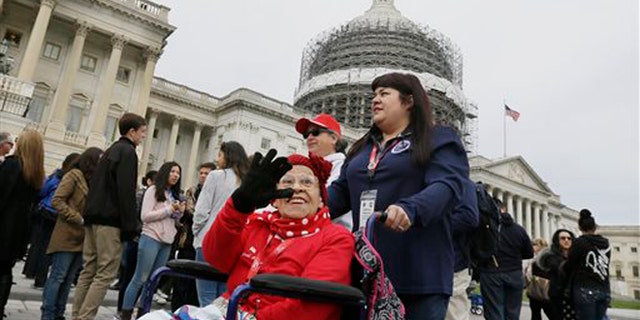 Former Rosie, Cookie Garza, 96, pushed by her granddaughter Stephanie Hagaman, waves on the Capitol grounds, Tuesday, March 22, 2016 in Washington. Seven decades after their we can do it attitude proved invaluable to the Allied victory in World War II, about 30 Rosie the Riveters were honored Tuesday with a visit to Washington. (AP Photo/Carlos Osorio)